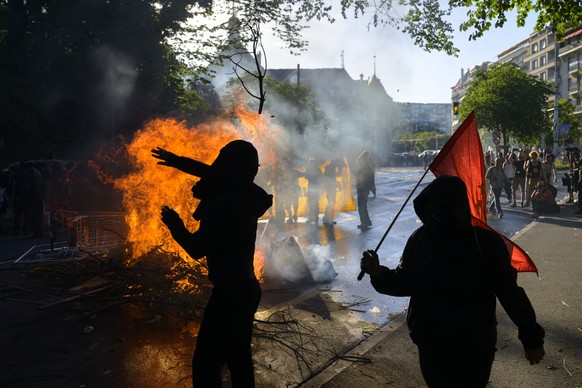 epa13036832 No-G7 activists next to a fire in the middle of a street during a demonstration against the G7 summit in Geneva, Switzerland, 14 June 2026. Protests opposing the G7 summit, which is schedu ...