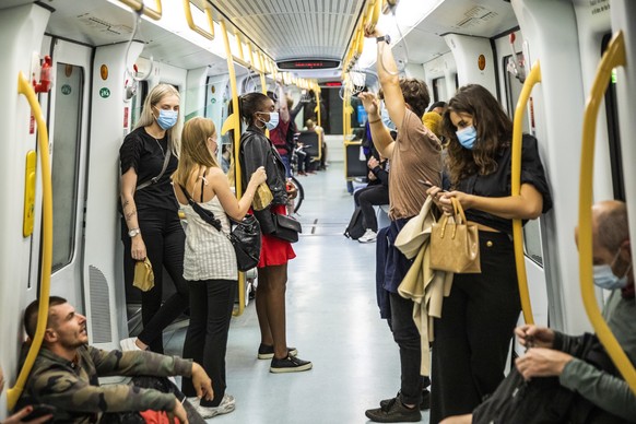 epa08617760 People ride the Metro wearing face masks, shortly after midnight, in Copenhagen, Denmark, 22 August 2020. The Danish government&#039;s demand for face mask or visor in public transport to  ...