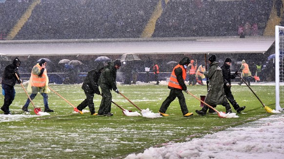 epa09630306 Groundskeepers clean the pitch from the snow before the UEFA Champions League group F soccer match between Atalanta BC and Villarreal CF at the Gewiss stadium in Bergamo, Italy, 08 Decembe ...