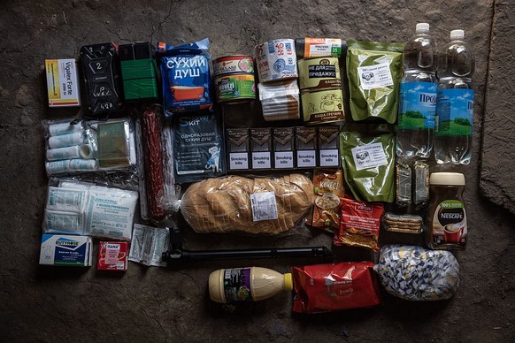 EASTERN UKRAINE - AUGUST 19: Food, medicine, a periscope, cigarettes and other items are laid out for a photo to show what is in packages to be delivered by drone to frontline soldiers on August 19th  ...