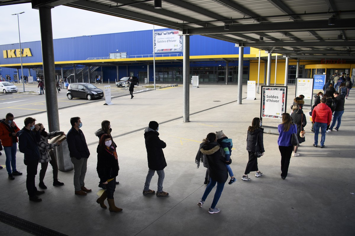 People wearing protective face mask line up in a queue outside the Swedish furniture giant Ikea shop the last day of the opening of non-essential shops during the coronavirus disease (COVID-19) outbre ...