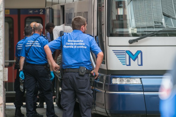 Grenzwaechter inspizieren einen Bus mit Fluechtlingen, am Dienstag, 12. Juli 2016, auf dem Bahnhof in Chiasso. Die Fluechtlinge wollten mit einem Bus nach Deutschland gelangen, konnten aber an der Sch ...