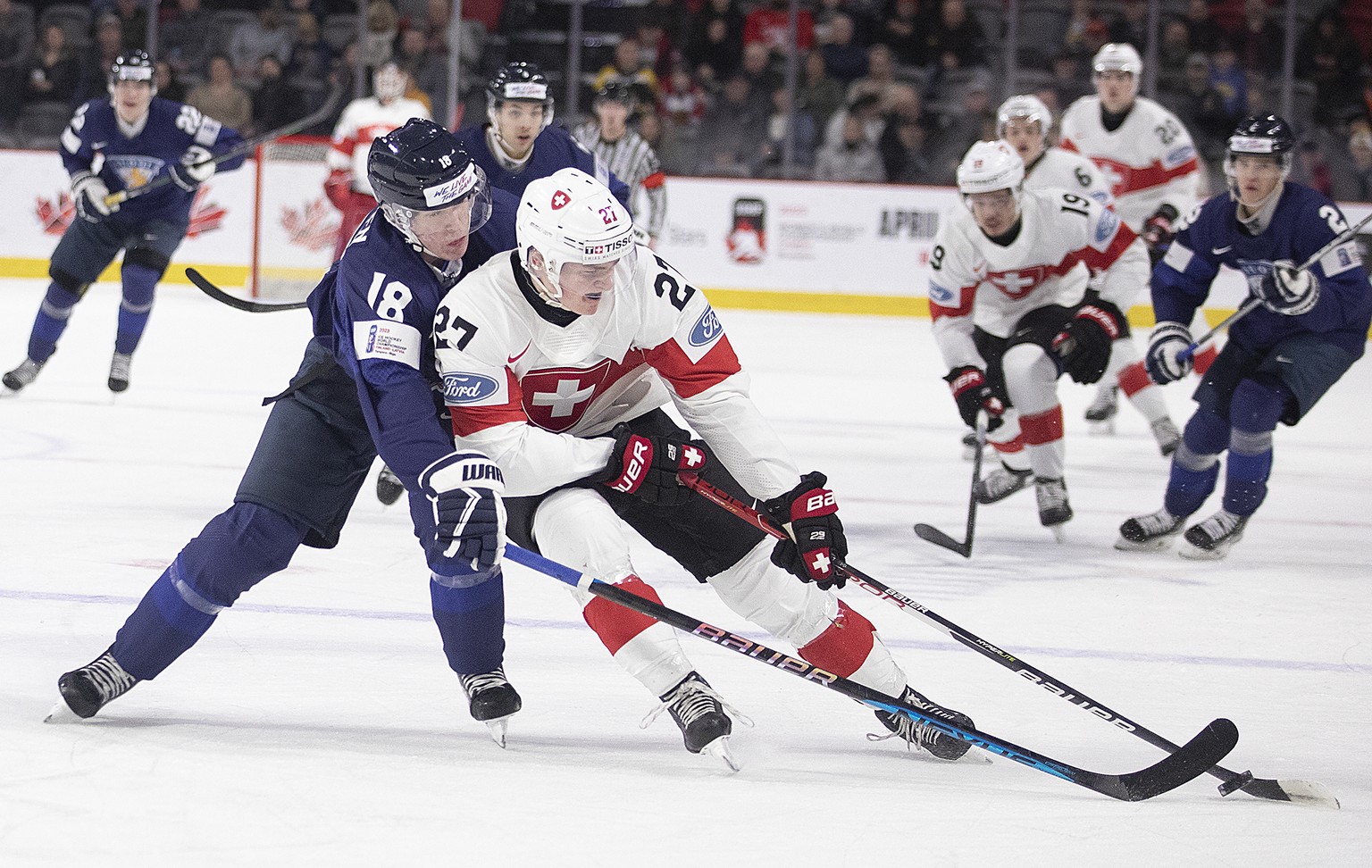 Switzerland&#039;s Miles Muller gets around Finland&#039;s Vemer Miettinen during first period IIHF World Junior Hockey Championship hockey game in Moncton, N.B., on Monday, Dec. 26, 2022. (Ron Ward