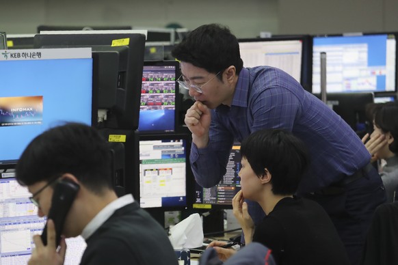 Currency traders watch monitors at the foreign exchange dealing room of the KEB Hana Bank headquarters in Seoul, South Korea, Friday, Jan. 3, 2020. Asian stocks were mixed Friday and oil prices surged ...