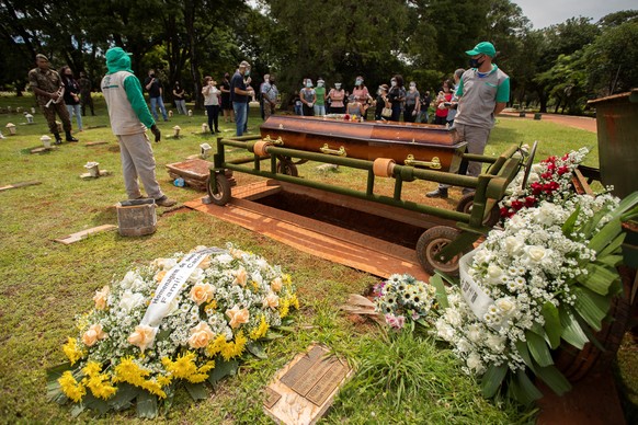 epa09099727 People attend a funeral in the cemetery Campo de Esperanza, in Brasilia, Brazil, 26 March 2021. Brazil joined the club of the nations producing its own vaccine against Covid-19, in order t ...