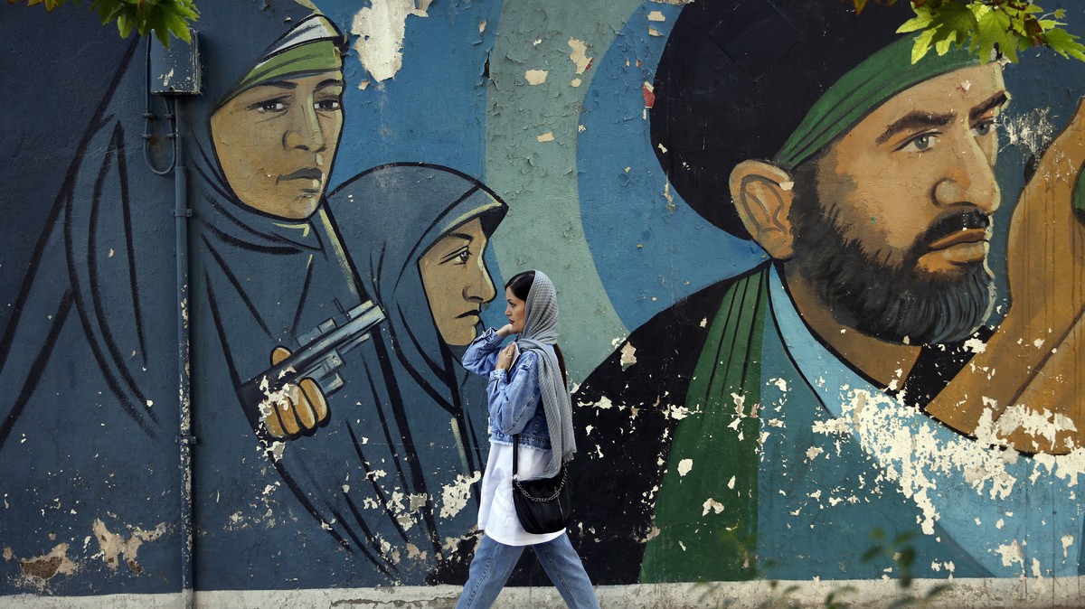 epa10923619 An Iranian woman walks past a mural in 'Palestine Square', in Tehran, Iran, 17 October 2023. Iranian supreme leader Ayatollah Ali Khamenei on 17 October 2023 warned Israel to sto ...