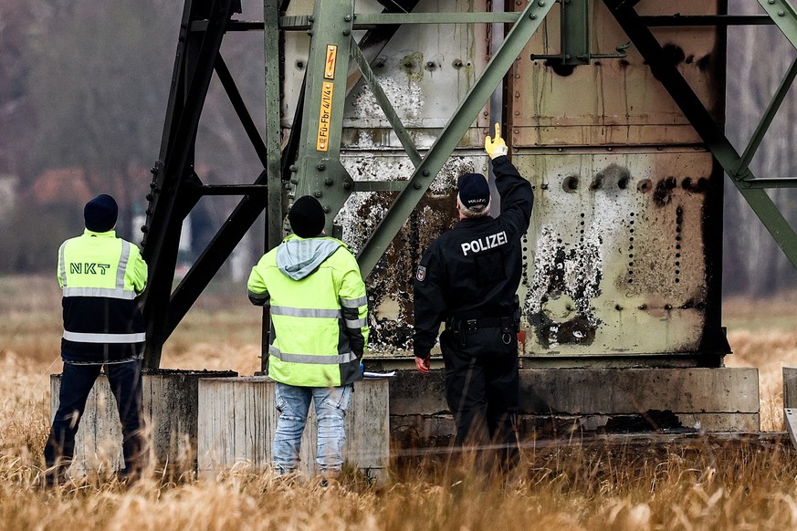 epa11199963 Police investigators inspect a damaged high-voltage pylon near the Tesla Gigafactory in Gruenheide near Berlin, Germany, 05 March 2024. Tesla confirms that production at the Tesla Gigafact ...