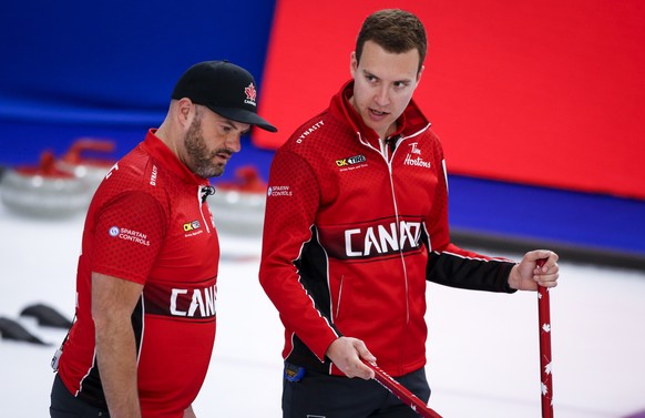 Team Canada skip Brendan Bottcher, right, and third Darren Moulding discuss strategy against Switzerland at the Men&#039;s World Curling Championships in Calgary, Alberta, Sunday, April 4, 2021. (Jeff ...