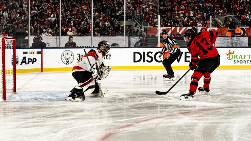 New Jersey Devils center Nico Hischier (13) shoots against Philadelphia Flyers goaltender Samuel Ersson, left, in the first period of an NHL Stadium Series hockey game in East Rutherford, N.J., Saturd ...