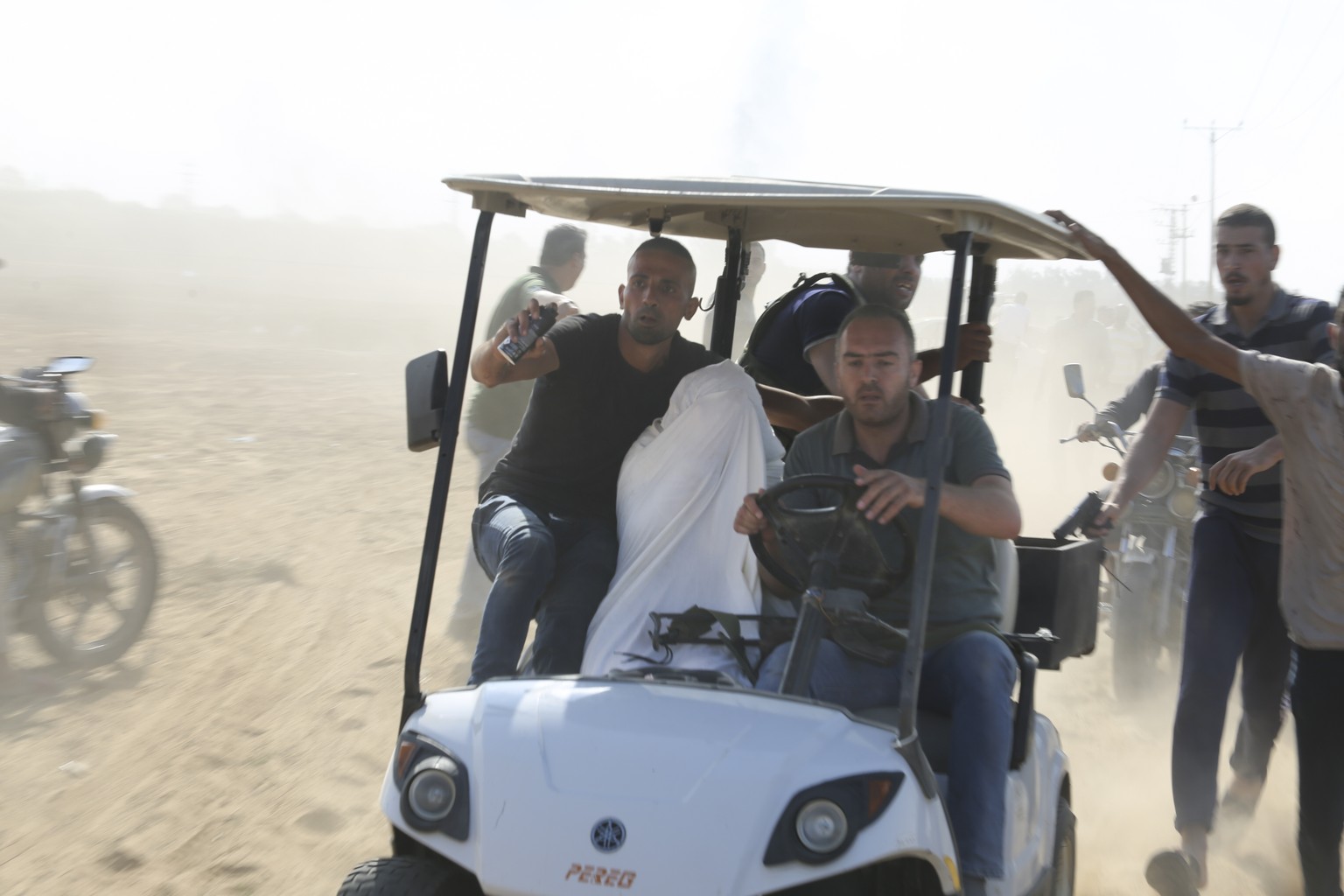 Palestinians transport a captured Israeli civilian from Kfar Azza kibbutz into the Gaza Strip on Saturday, Oct. 7, 2023. The militant Hamas rulers of the Gaza Strip carried out an unprecedented, multi ...