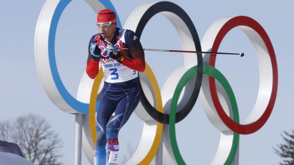 FILE - In this Feb. 23, 2014 file photo Russia&#039;s gold medal winner Alexander Legkov skis past the Olympic rings during the men&#039;s 50K cross-country race at the 2014 Winter Olympics in Krasnay ...