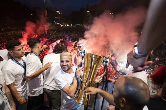 Die Zuercher feiern ihren Meistertitel mit dem Pokal mit ihren Fans auf dem Balkon des Volkshauses, am Sonntag, 22. Mai 2022 auf dem Helvetiaplatz in Zuerich. (KEYSTONE/Ennio Leanza)