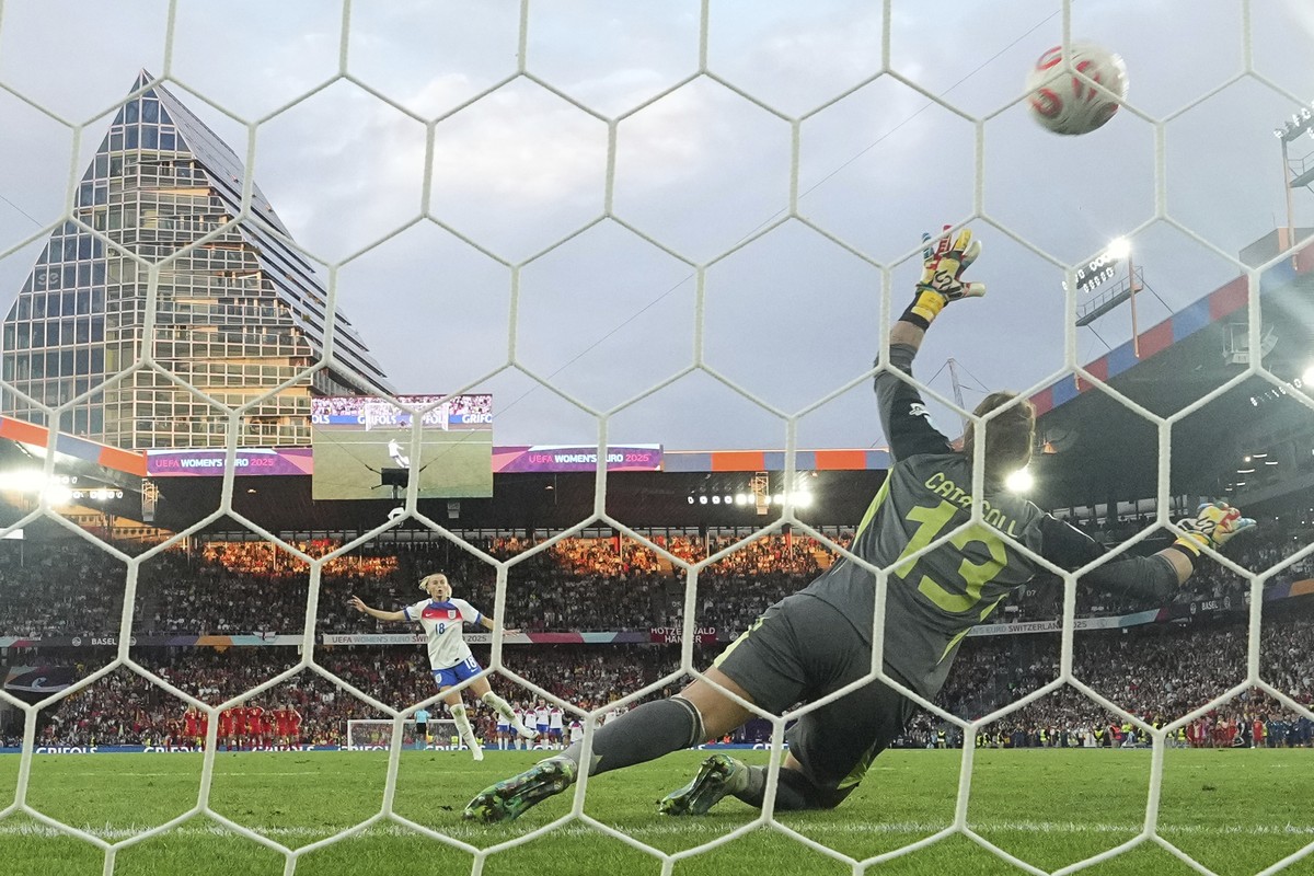 England's Chloe Kelly, left, scores the winning penalty against Spain goalkeeper Catalina Coll during the Women's Euro 2025 final soccer match between England and Spain at St. Jakob-Park in  ...
