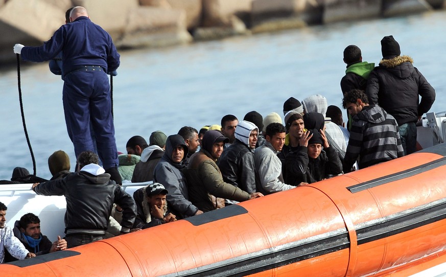 epa02671122 Immigrants are being transported on a Coast Guard boat after they arrive on Lampedusa Island, Italy, 05 April 2011. The wave of landings has resumed after big transfers to the mainland in  ...