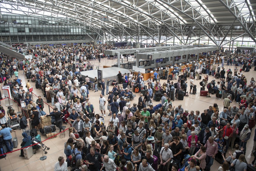 Travellers queue during a blackout at the airport in Hamburg, Germany, Sunday, June 3, 2018. (Daniel Reinhardt/dpa via AP)