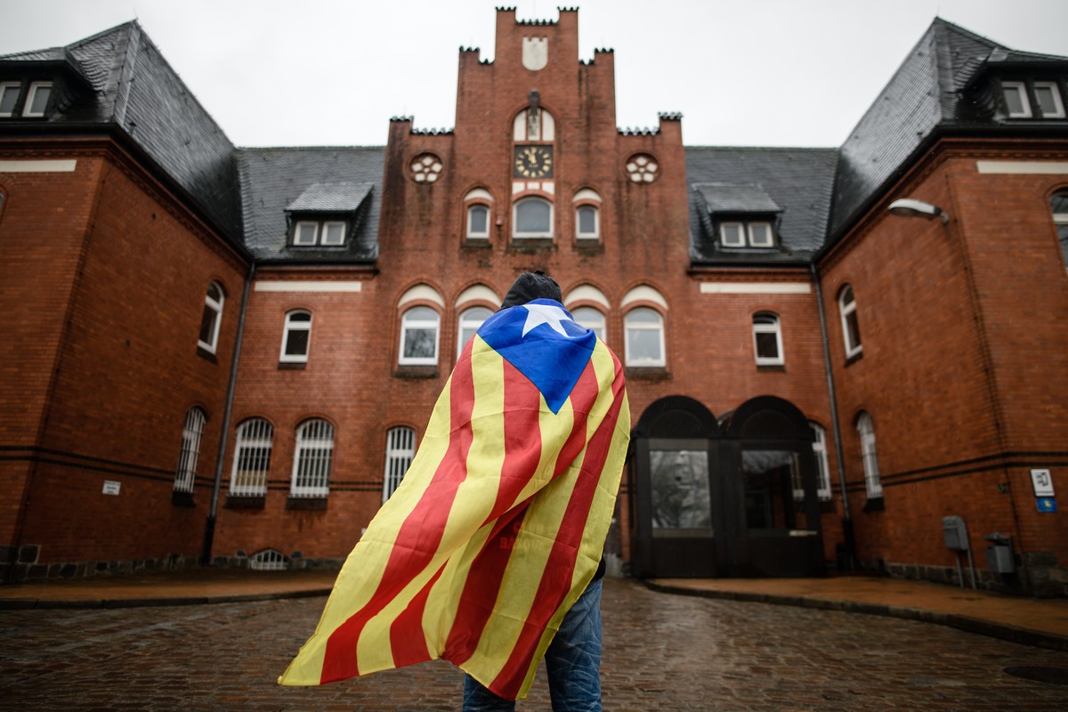 epaselect epa06640131 Catalan sympathizer Eduardo Alonso has a Catalonian Independence flag wrapped around his shoulders as he waits in front of the 'Justizvollzugsanstalt (JVA) Neumuenster' ...