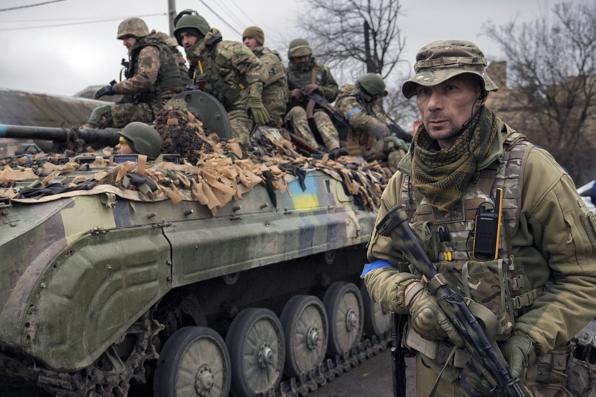 FILE - A Ukrainian serviceman walks next to a fighting vehicle, outside Kyiv, Ukraine, Saturday, April 2, 2022. As he begins a second term as France's president, Emmanuel Macron has given the gre ...
