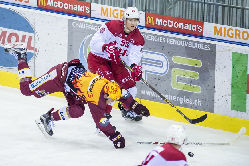 Le joueur lausannois, Martin Gernat, droite, a la lutte pour le puck avec le joueur genevois, Tanner Richard, gauche, lors du match du championnat suisse de hockey sur glace de National League, entre  ...