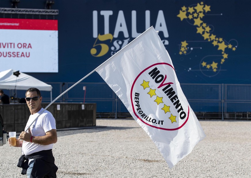 An activist carries a flag as Italy’s Five Stars Movement holds two-day rally at Rome’s Circus Maximus, in Rome, Italy, Saturday, Oct. 20, 2018. (Massimo Percossi/ANSA via AP)