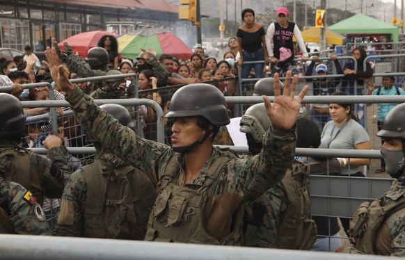 A soldier asks for calm from the friends and family members of inmates seeking information after deadly clashes at the Litoral Penitentiary, in Guayaquil, Ecuador, Tuesday, July 25, 2023. Ecuador on T ...