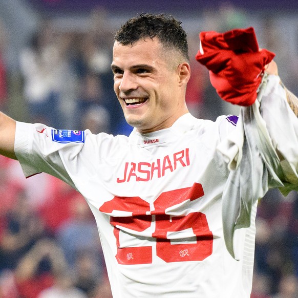 Switzerland&#039;s midfielder Granit Xhaka celebrates the victory and the qualification with the shirt of Switzerland&#039;s midfielder Ardon Jashari after the FIFA World Cup Qatar 2022 group G soccer ...