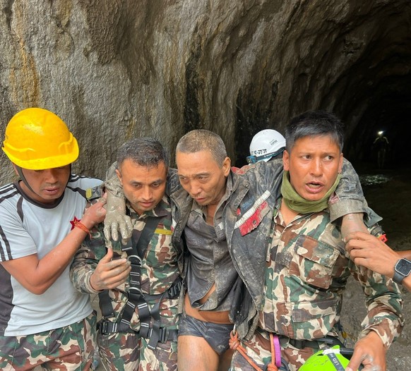 epa13213453 A handout photo made available by the Nepal Army shows a Chinese survivor (2-R) being rescued from a tunnel at the Upper Trishuli 1 Hydropower Project in Rasuwa district, Nepal, 05 Septemb ...