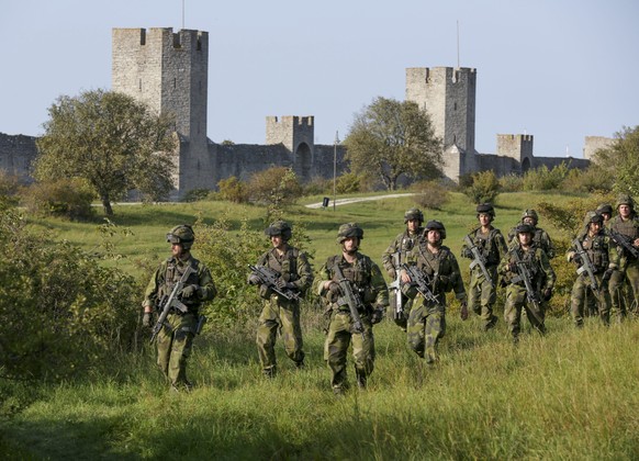 epa05539256 A squad from the Swedish Army&#039;s Skaraborg Armoured Regiment patrols outside Visby&#039;s 13th century city wall during a military maneuver in Visby, on the island of Gotland, 14 Septe ...