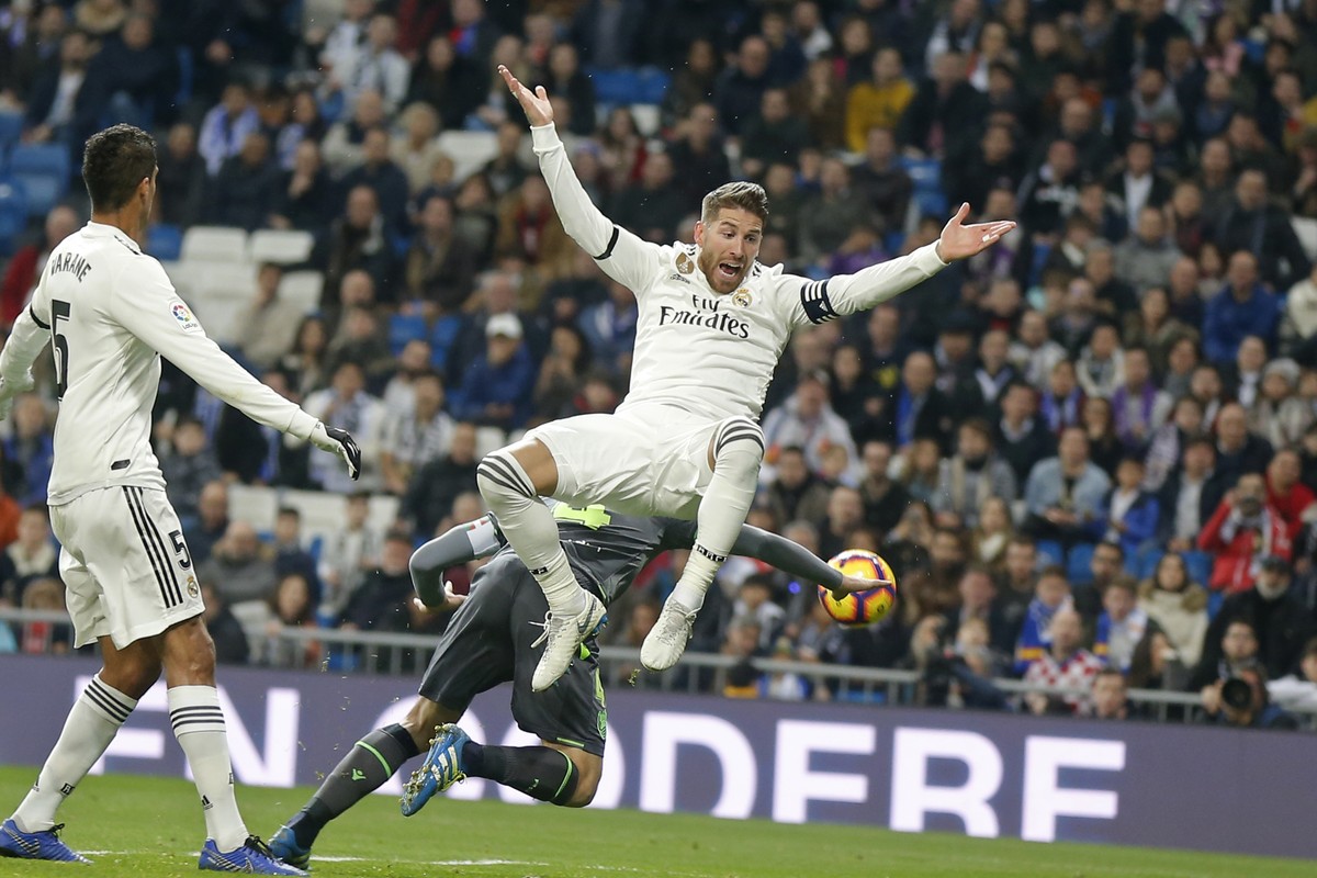 Real Madrid's Sergio Ramos jumps, with Real Sociedad's Asier Illarramendi, obscured behind, during a Spanish La Liga soccer match between Real Madrid and Real Sociedad at the Santiago Bernab ...
