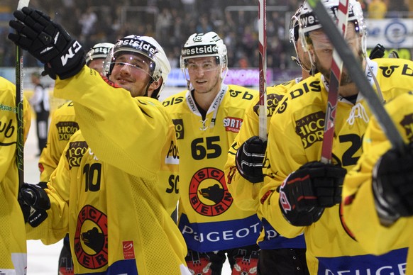 LÕattaquant bernois Tristan Scherwey, gauche, et le defenseur bernois Ramon Untersander, centre, saluent les supporters apres la rencontre du championnat suisse de hockey sur glace de National League, ...