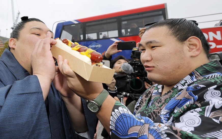 Sumo: London tournament Sumo grand champions Onosato L and Hoshoryu share a hotdog while sightseeing in London on Oct. 14, 2025, as about 120 sumo wrestlers are set to take part in a five-day local to ...