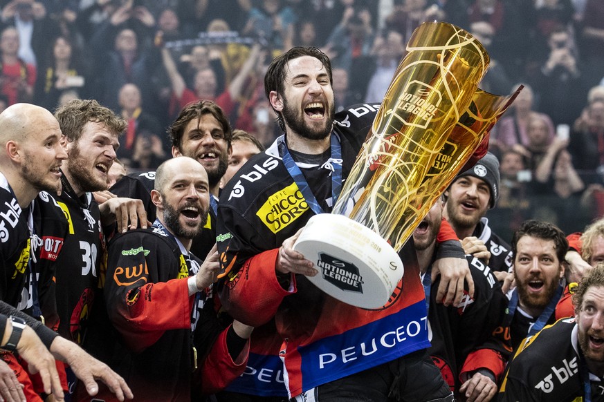 Simon Moser und die Spieler des SC Bern feiern mit dem Pokal den Schweizermeistertitel nach dem Sieg im fuenften Eishockey Playoff-Finalspiel der National League zwischen dem SC Bern und dem EV Zug, a ...