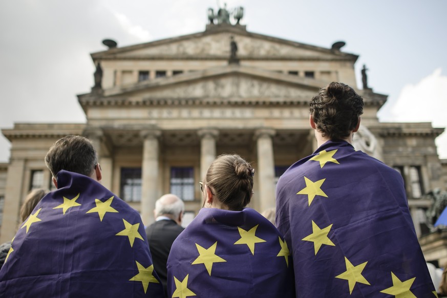 epaselect epa05884429 People have themselves wrapped in European Union (EU) flags as they gather for a pro-European Union rally titled &#039;Pulse of Europe&#039; at the Gendarmenmarkt square in Berli ...