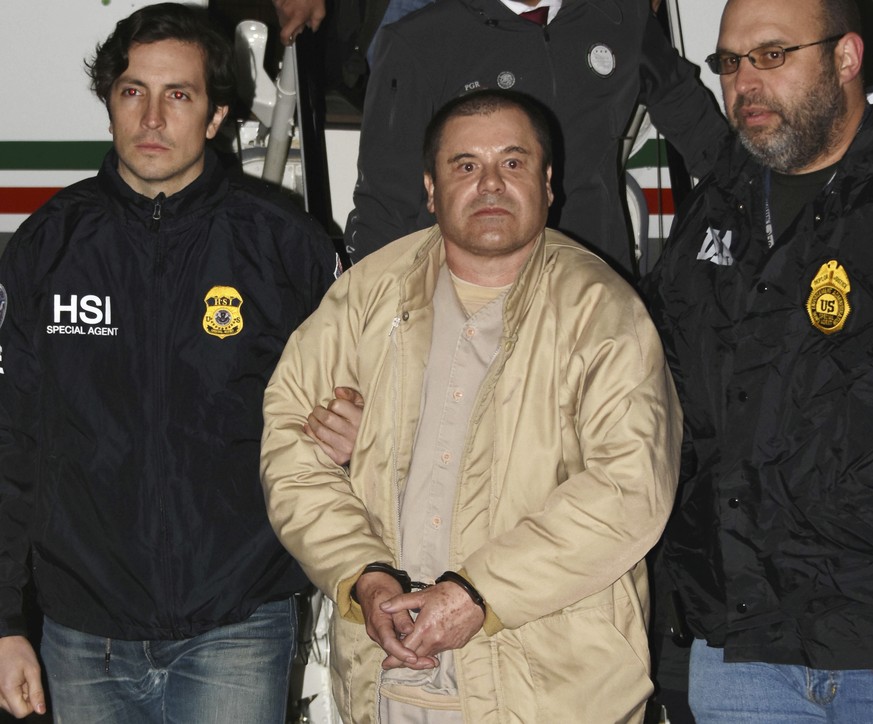 In this Jan. 19, 2017 photo provided by the United States Drug Enforcement Administration, authorities escort Joaquin &quot;El Chapo&quot; Guzman, center, from a plane to a waiting caravan of SUVs at  ...