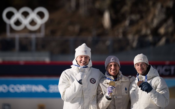 260213 Silver medalist Vetle Sjastad Christiansen of Norway, gold medalist Quentin Fillon Maillet of France and bronze medalist Sturla Holm Laegreid of Norway on the podium in men s biathlon 10 km spr ...