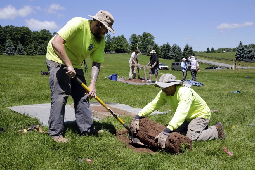 In this Thursday, June 14, 2018 photo, Jesse Pagels, left, and Edgar Alarcon, of the Public Archaeology Facility at Binghamton University, start a new dig at the site of the original Woodstock Music a ...