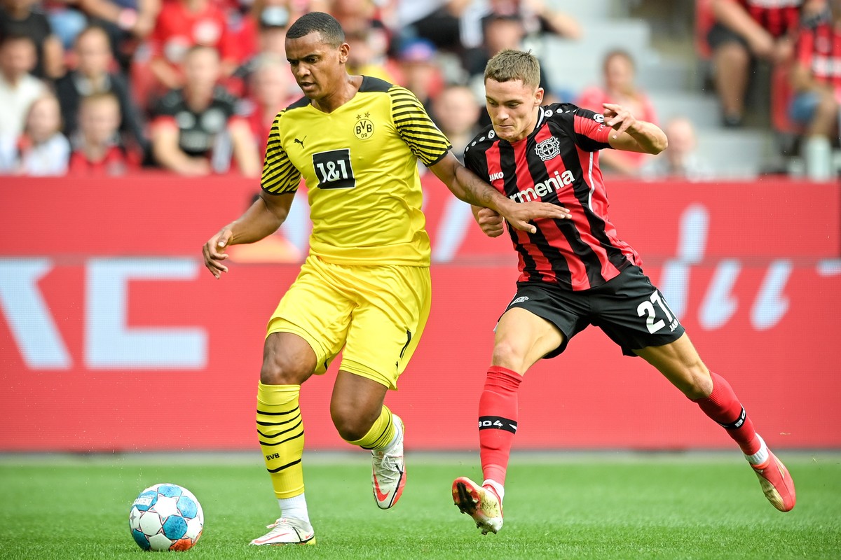 epa09461176 Dortmund's Manuel Akanji (L) in action against Leverkusen's Florian Wirtz (R) during the German Bundesliga soccer match between Bayer Leverkusen and Borussia Dortmund in Leverkus ...