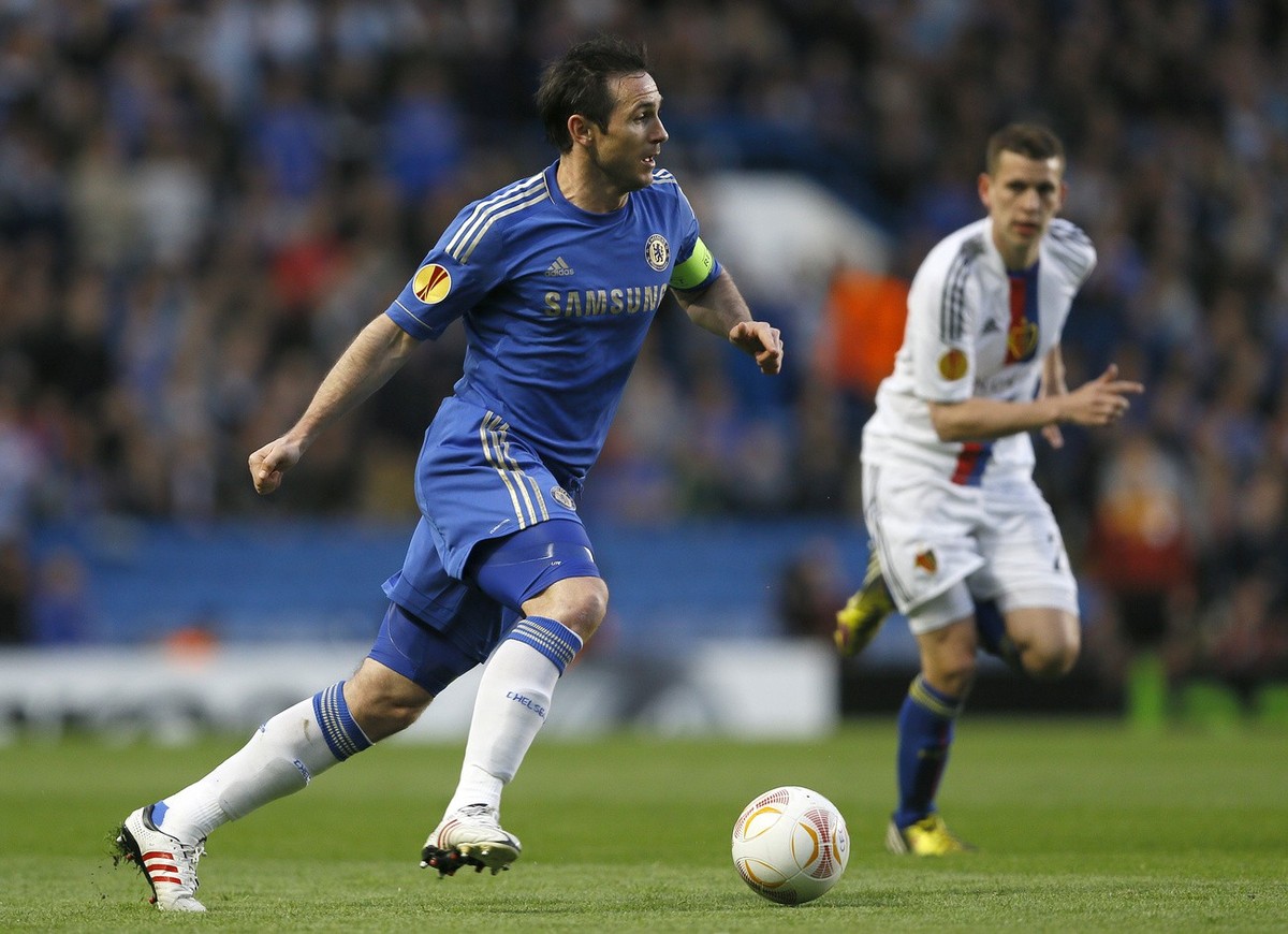 Chelsea's Frank Lampard, left, takes the ball forward watched by Basel's Fabian Frei during their Europa League semifinal second leg soccer match, at Chelsea's Stamford Bridge stadium i ...