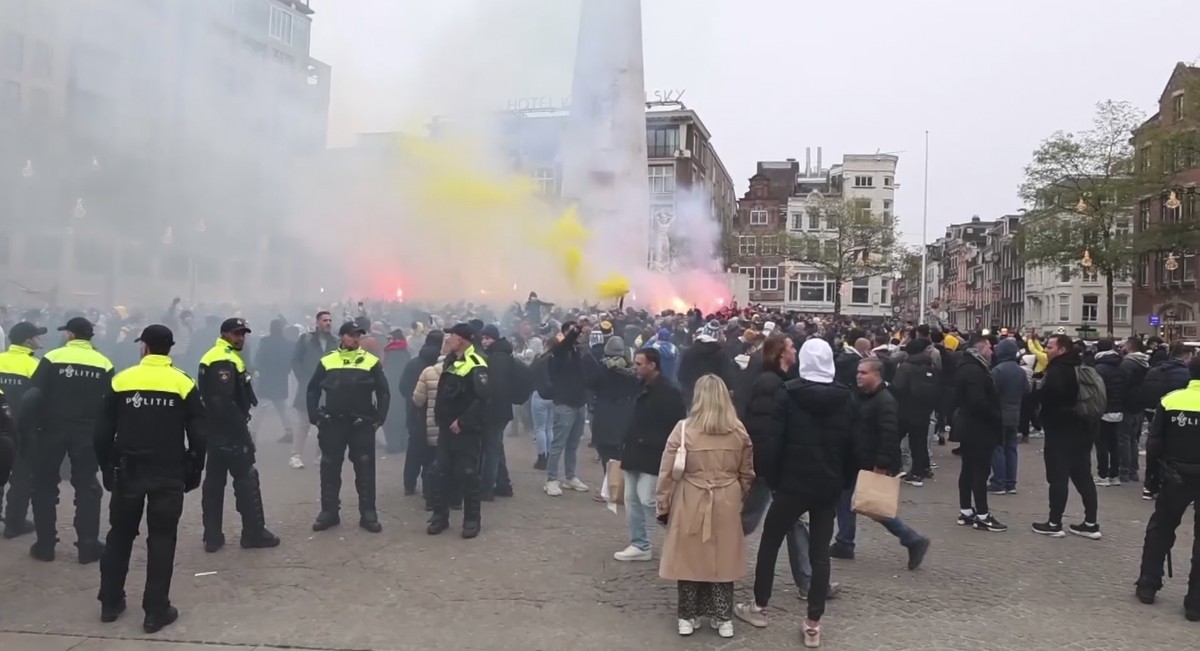FILE - In this image taken from video, police stand guard as Maccabi Tel Aviv supporters light flares at the Dam square, in Amsterdam, the Netherlands, Thursday, Nov. 7, 2024. (AP Photo InterVision, F ...