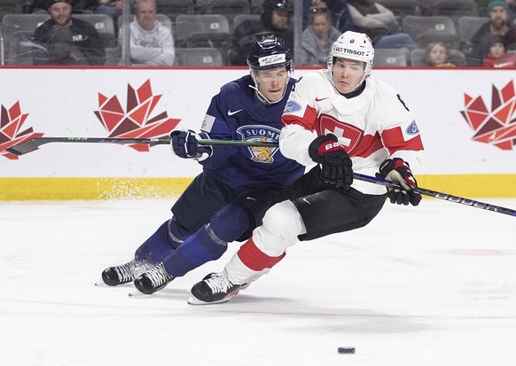 December 26, 2022, Moncton, NB, Canada: Switzerland s Mats Alge cuts to the net as Findland s Otto Salin follows during third period IIHF World Junior Hockey Championship hockey action in Moncton, N.B ...