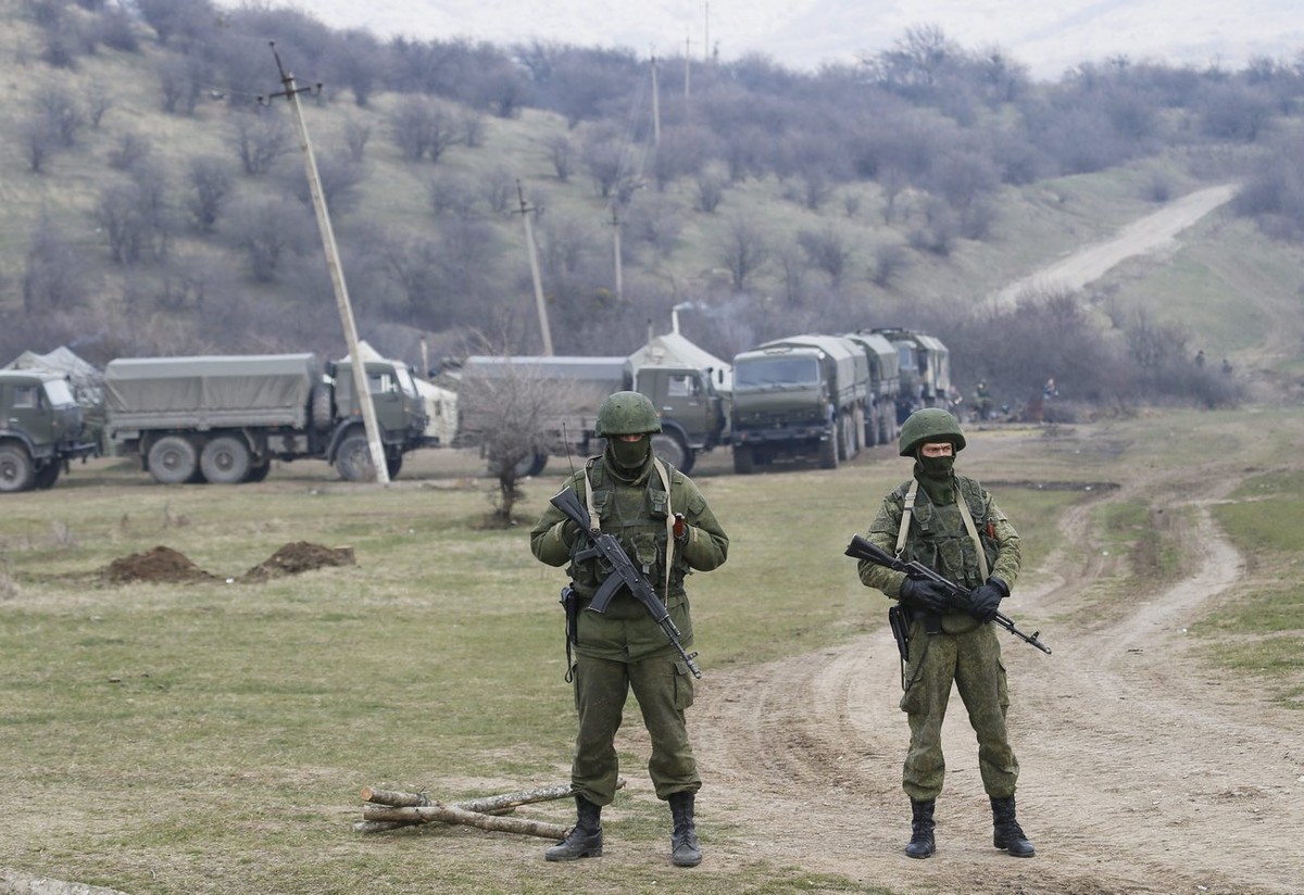 epa04121666 Armed men in military uniform are seen outside the territory of Ukrainian military unit in the village of Perevalnoye, outside Simferopol, Ukraine, 12 March 2014. Crimea's secessionis ...