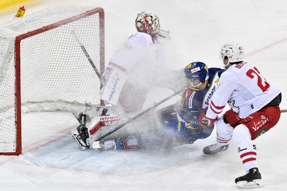 Der Davoser Fabrice Herzog, wird vom Lausanner Christoph Bertschy ins Tor vom Lausanner Torhueter Luca Boltshauser geschoben, im Eishockey-Qualifikationsspiel der National League zwischen dem HC Davos ...