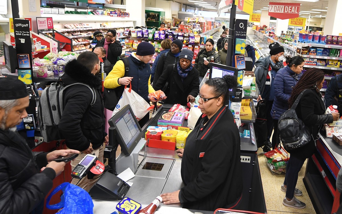 epa08306396 People queue at a supermarket in London, Britain, 19 March 2020. The UK's major supermarkets have requested police protection over fears coronavirus panic-buying could lead to rioting ...