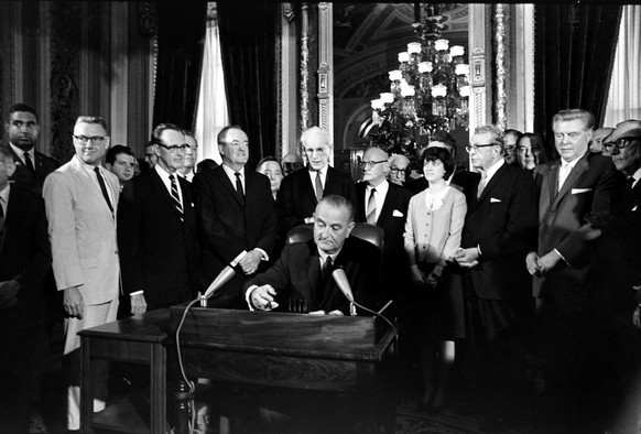 FILE - In this Aug. 6, 1965, photo, President Lyndon Baines Johnson signs the Voting Rights Act of 1965 in a ceremony in the President's Room near the Senate Chambers on Capitol Hill in Washington. Th ...