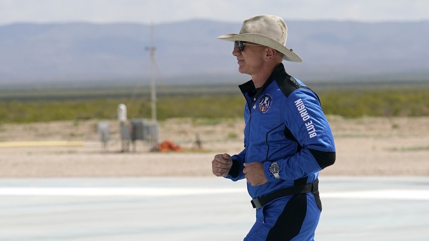 Jeff Bezos, founder of Amazon and space tourism company Blue Origin jogs onto the Blue Origin's New Shepard rocket landing pad to pose for photos at the spaceport near Van Horn, Texas, Tuesday, July 2 ...
