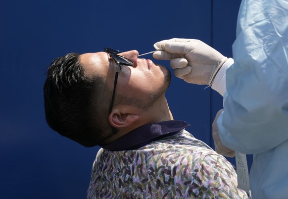 A nurse takes a sample for a COVID-19 PCR test at a market in Lima, Peru, Wednesday, Jan. 5, 2022. Peru confirmed on Tuesday the start of a third wave of new coronavirus infections. (AP Photo/Martin M ...