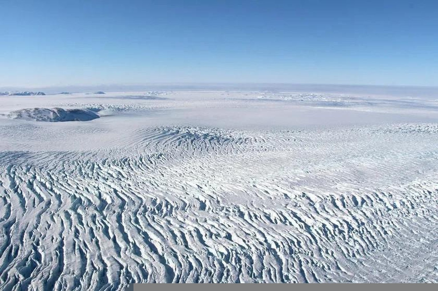 Spaltenbildung auf dem Eisschild in der Nähe der Küste der Melville-Bucht in Westgrönland. Die Risse treten durch die Dehnung des Eises auf, das in Küstennähe schneller fliesst. 