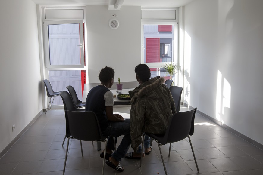 Two unaccompanied young refugees heat in a refectory, at the new center for young migrants of the General Hospice, in Geneva, Switzerland, Friday, January 22, 2016. The canton of Geneva on Friday inau ...