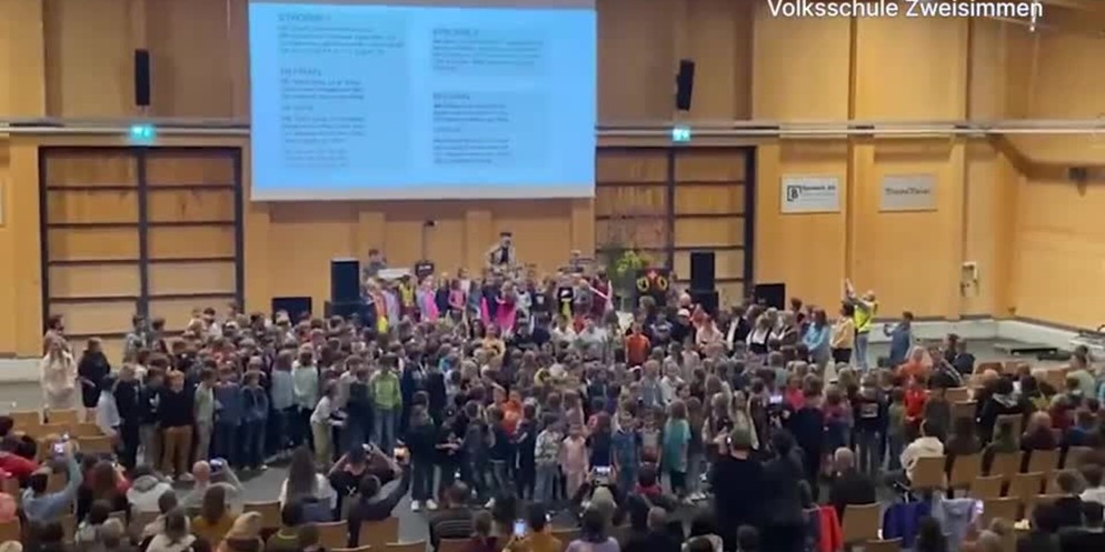 «Mir häbe Sorg» ist das gemeinsame Werk von 320 Schülerinnen und Schülern der Volksschule in Zweisimmen. Geholfen haben die Musiker eifachBen und Jesse Ritch. Zusammen mit den Kindern haben sie den So ...