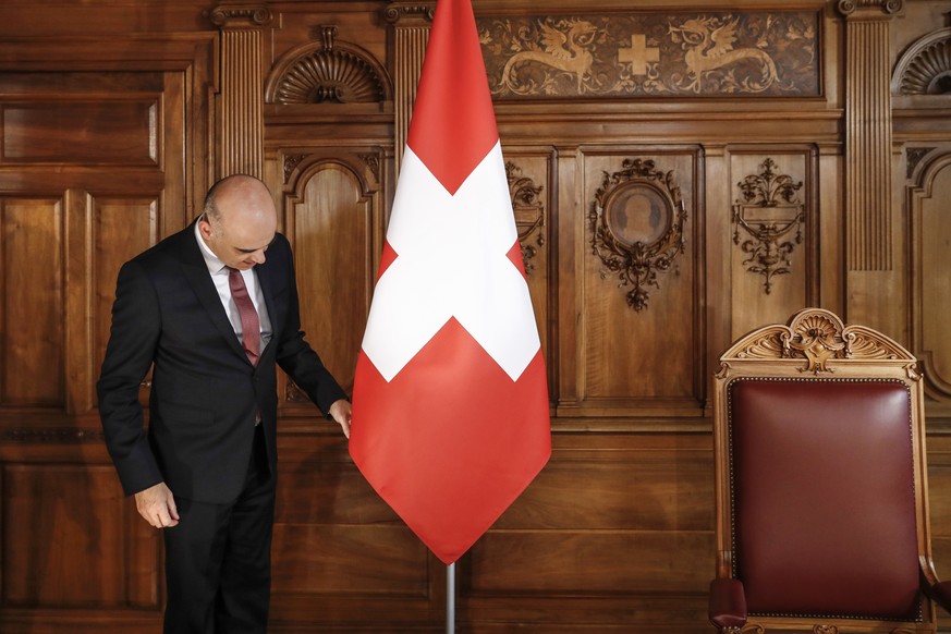 Bundespraesident Alain Berset zupft an der Schweizer Fahne vor der Aufzeichnung der Neujahrsansprache fuer das Jahr 2018, am Donnerstag, 21. Dezember 2017, im Bundesratszimmer in Bern. (KEYSTONE/Peter ...