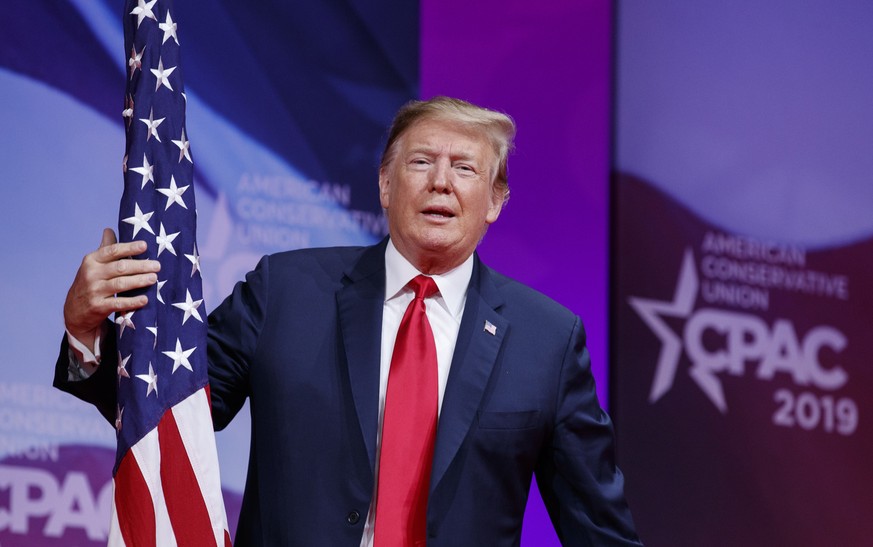 President Donald Trump hugs the American flag as he arrives to speak at Conservative Political Action Conference, CPAC 2019, in Oxon Hill, Md., Saturday, March 2, 2019. (AP Photo/Carolyn Kaster)